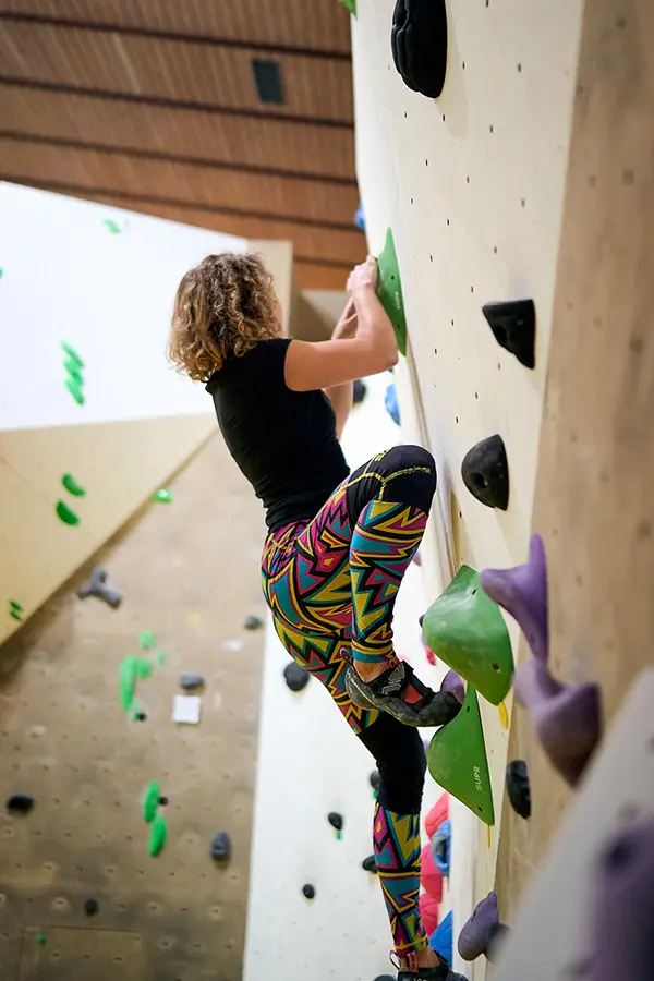 Frau klettert eine senkrechte Wand hoch
